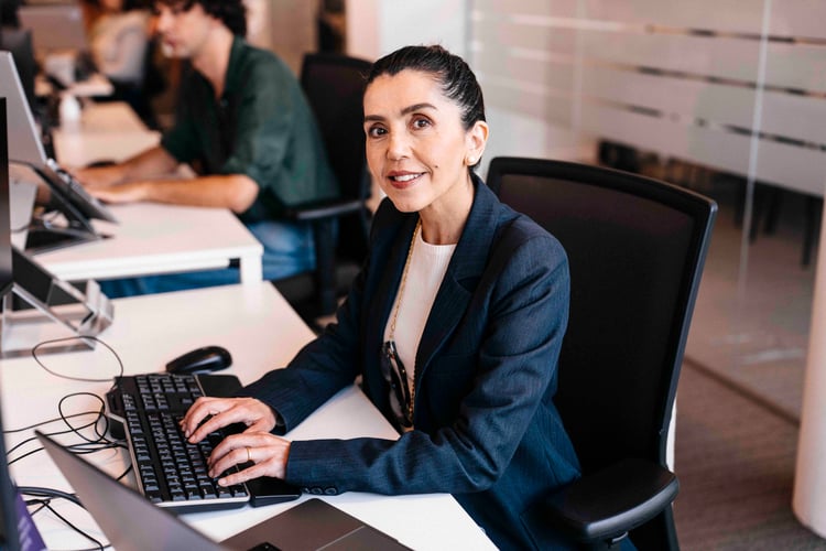 Vrouw typt op toetsenbord aan haar bureau